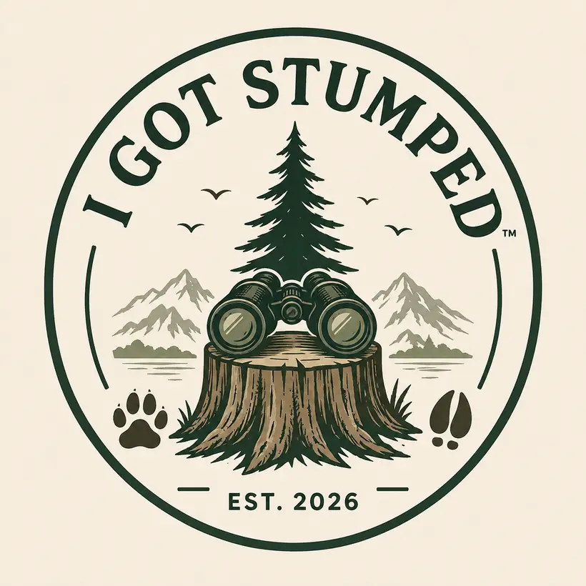 Circular badge with binoculars resting on a stump, mountains, paw and hoof prints, Est. 2026